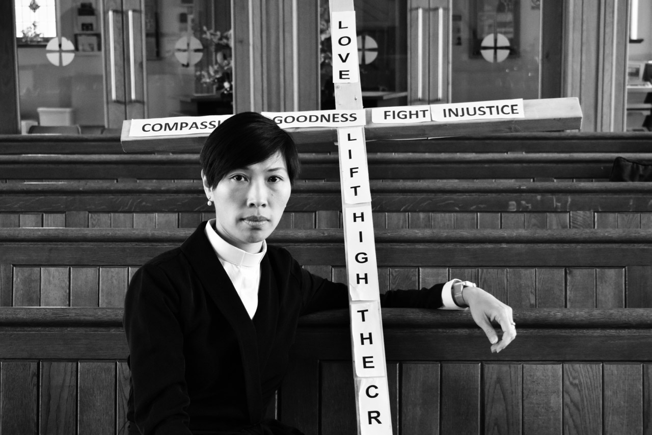 Woman sat down in Church holding cross