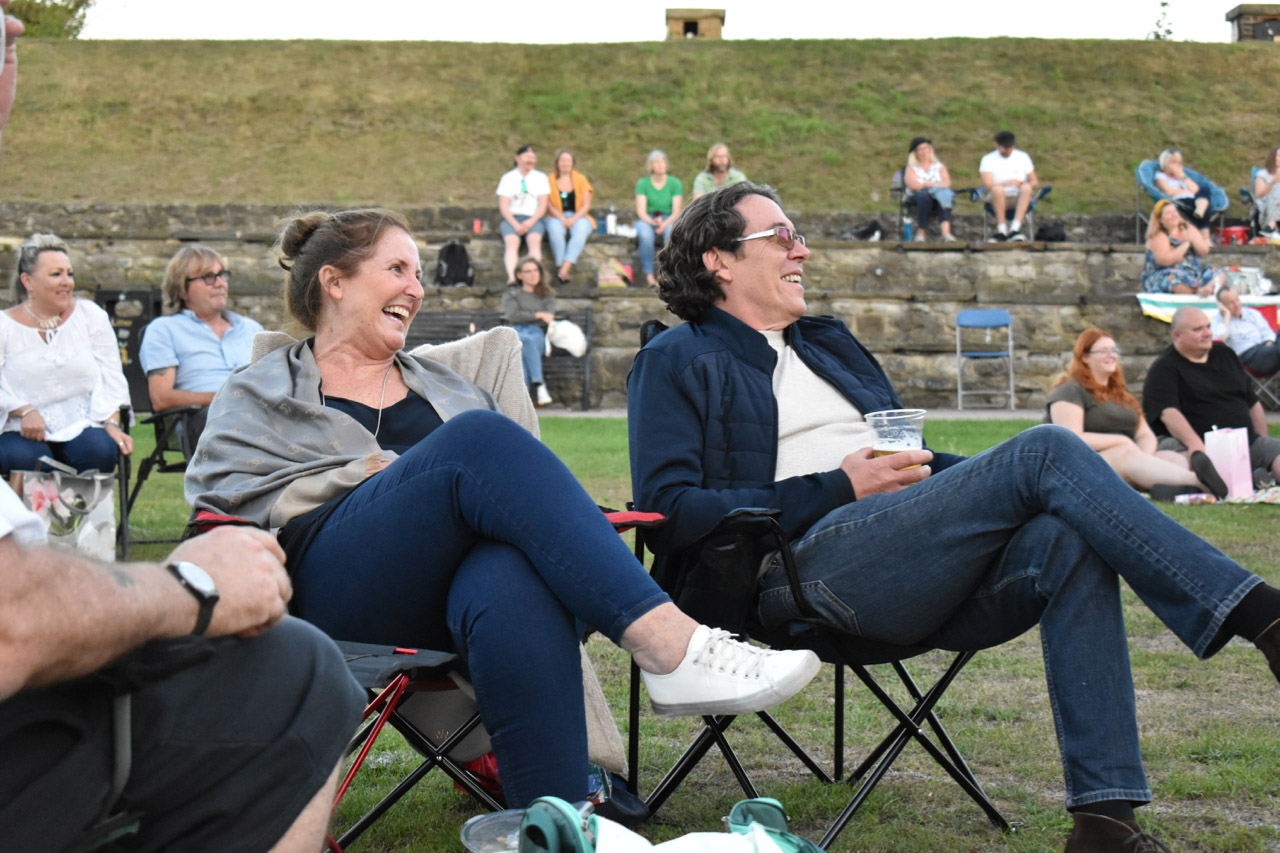 Seated crowd at outdoor comedy event