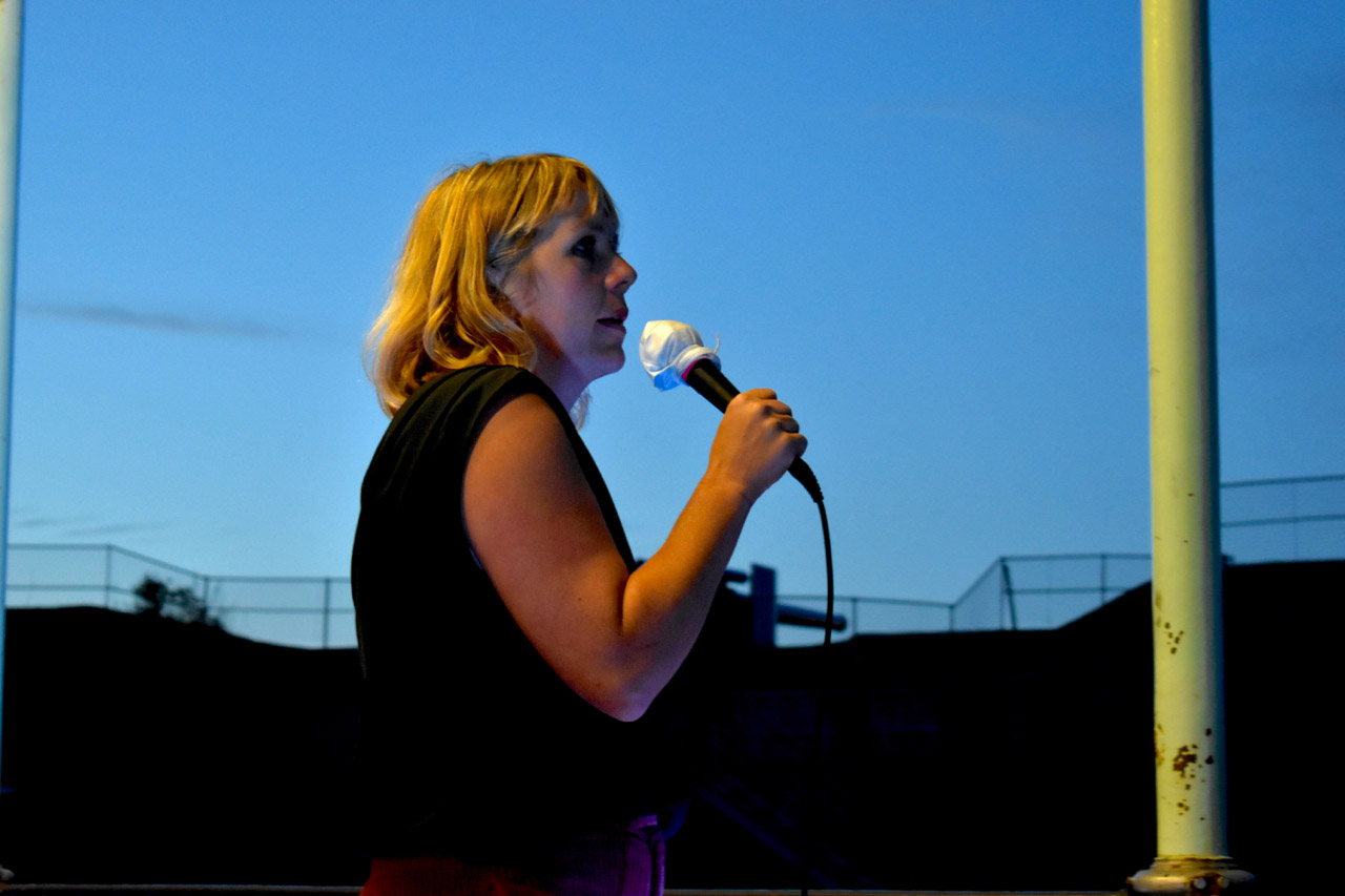 Comedienne on stage at outdoor comedy event