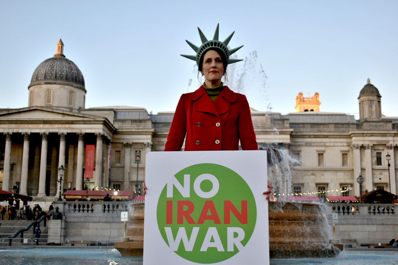 Woman holding No Iran war sign.