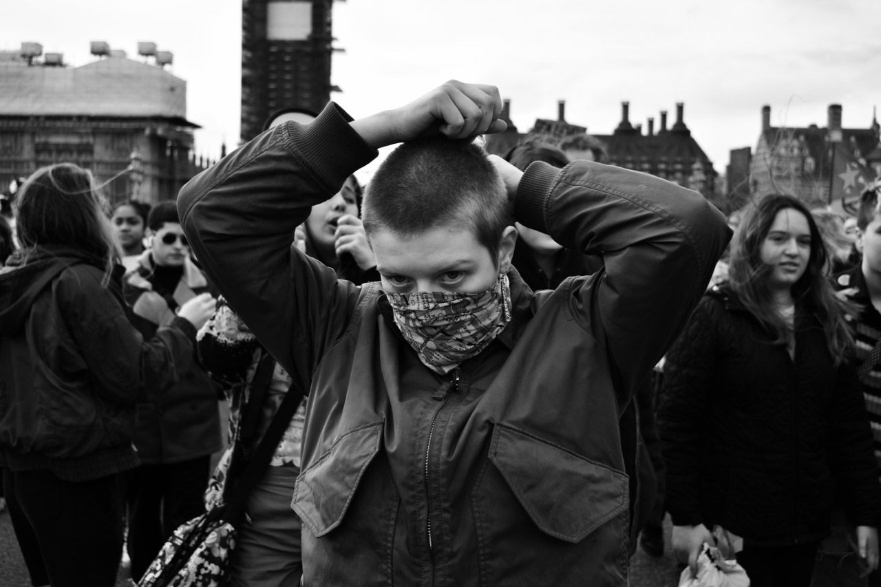 Protestor wearing scarf facemask.