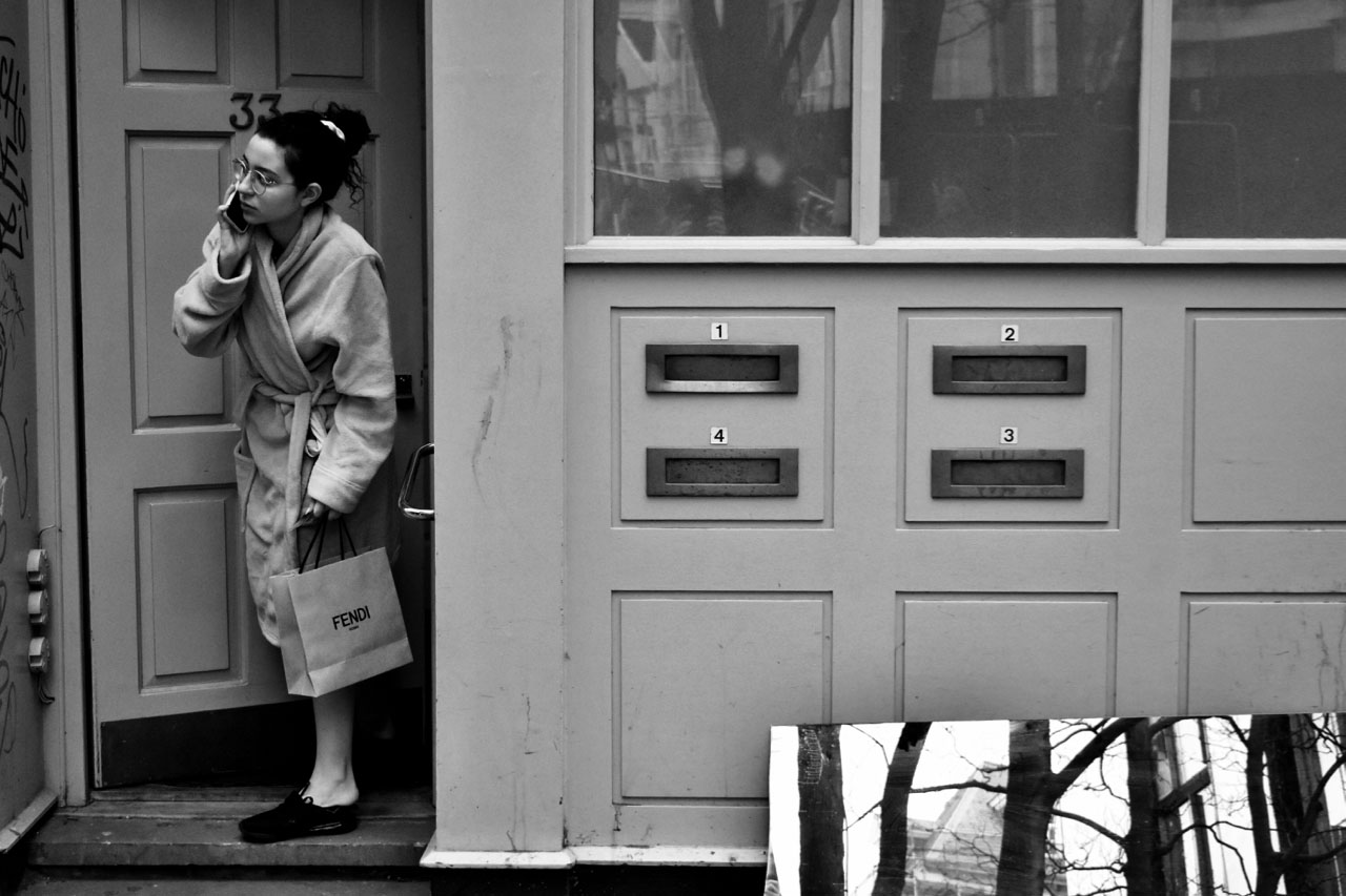 Image of a woman in doorway, wearing a dressing gown.