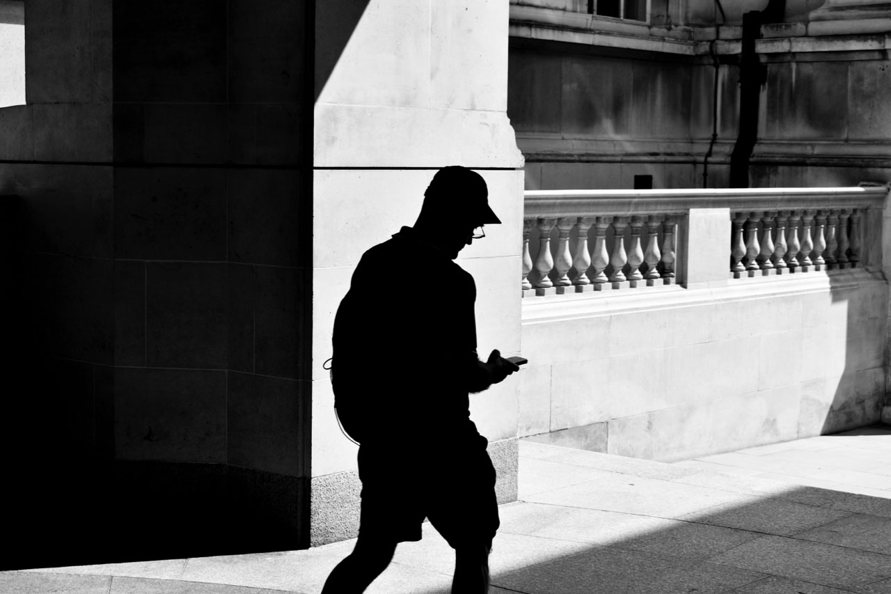 Image of silhouetted man in street.